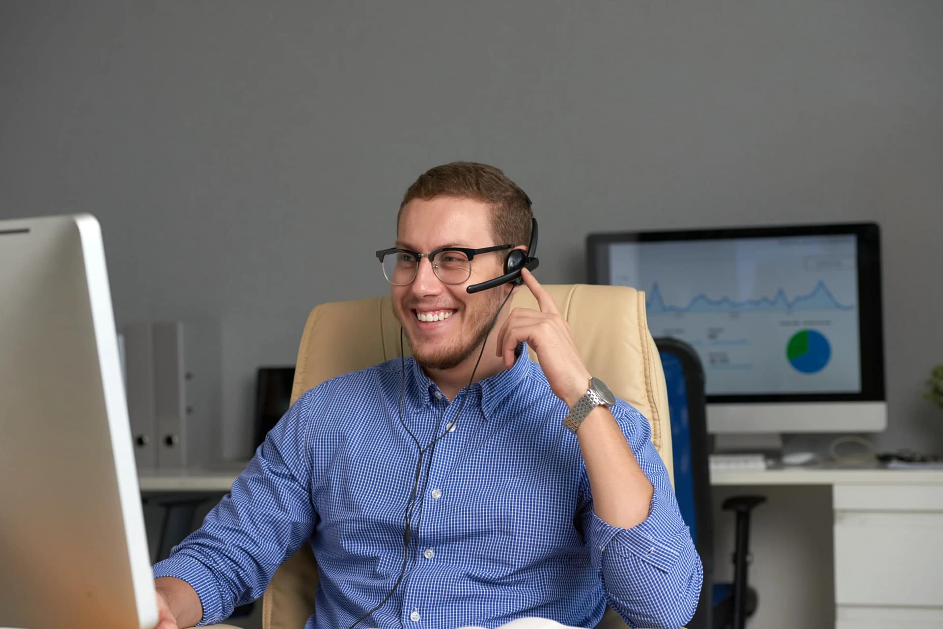 Smiling customer support agent at computer desk