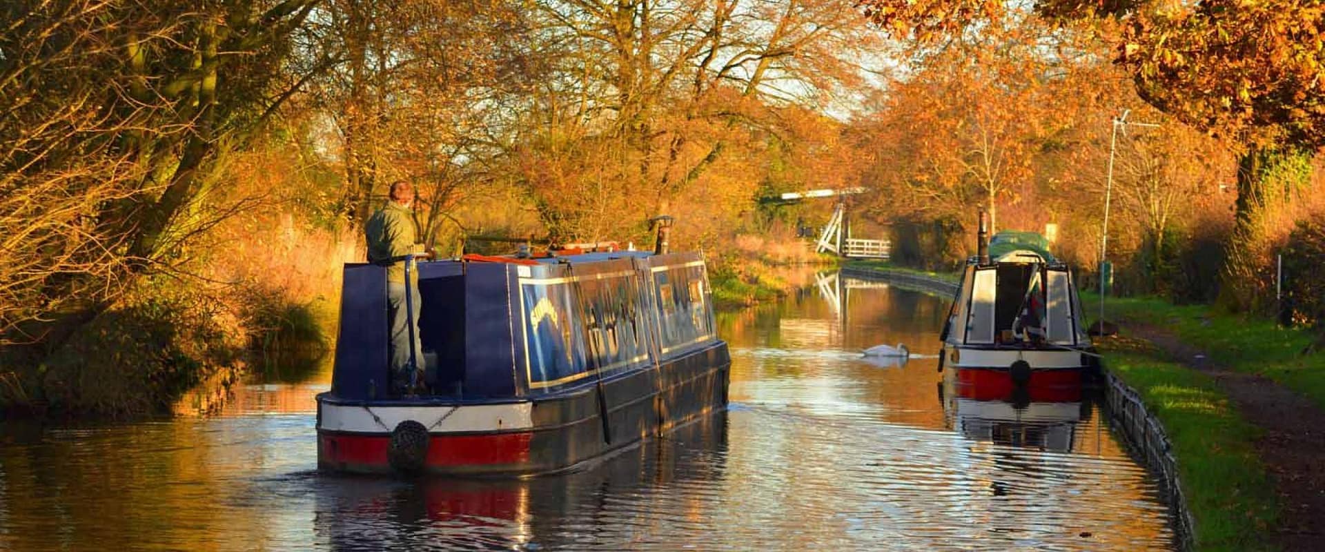 Narrowboats cruising on a peaceful autumn canal