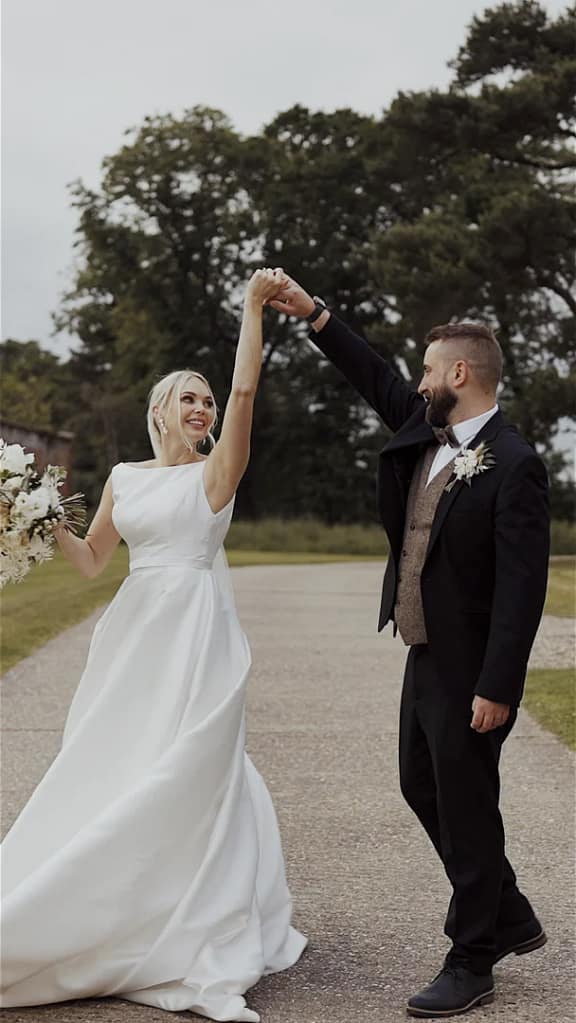 Bride and groom dancing outdoors on wedding day.