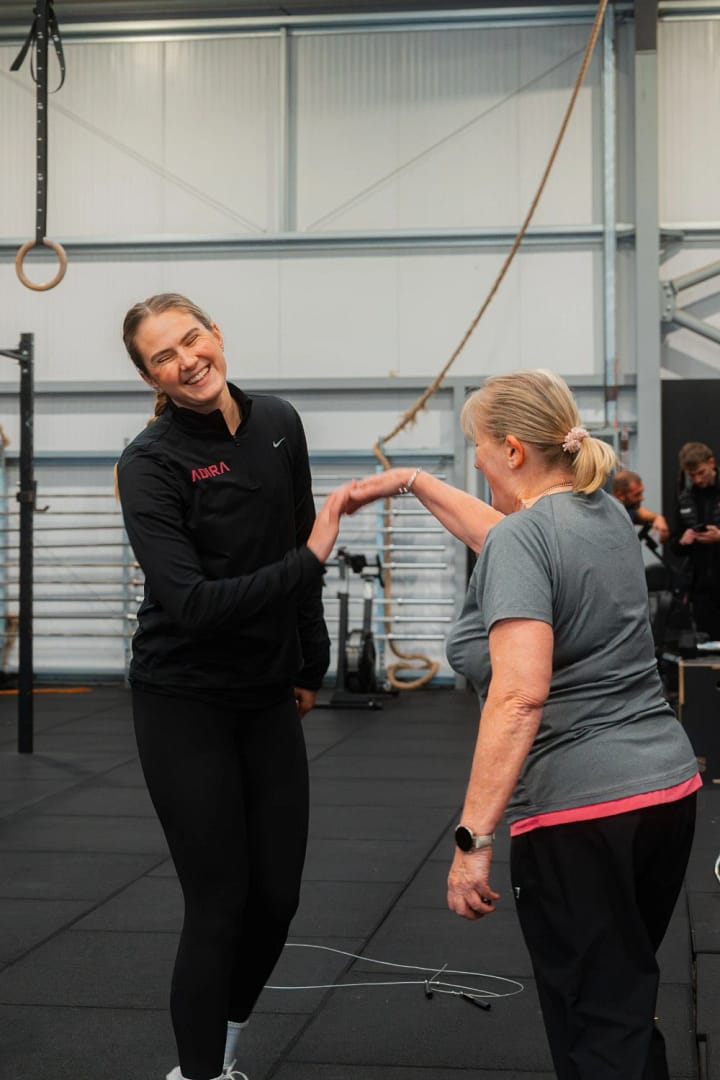 Two women high-fiving in a gym