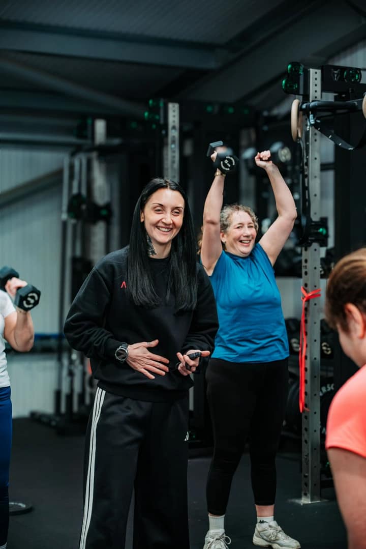 Women lifting dumbbells during gym training session