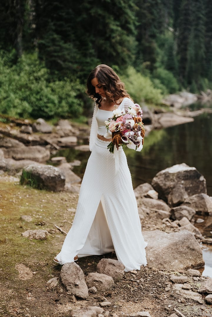 Bride with bouquet near a forested lake Gibson