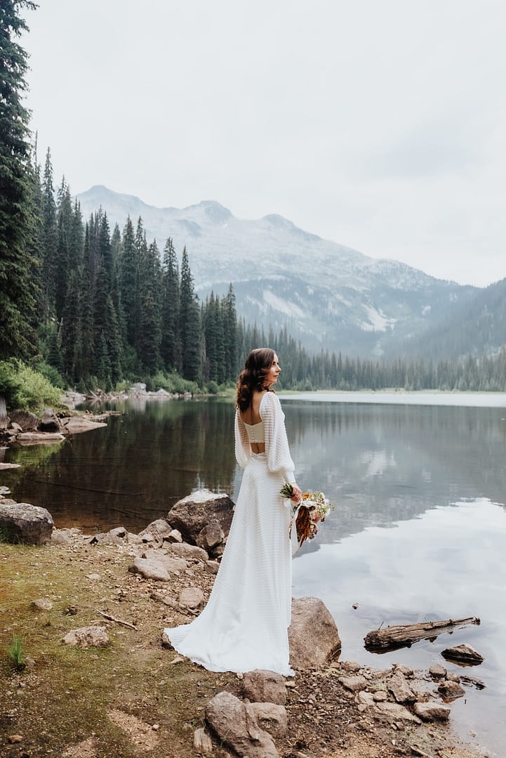Bride with bouquet by scenic mountain lake Gibson