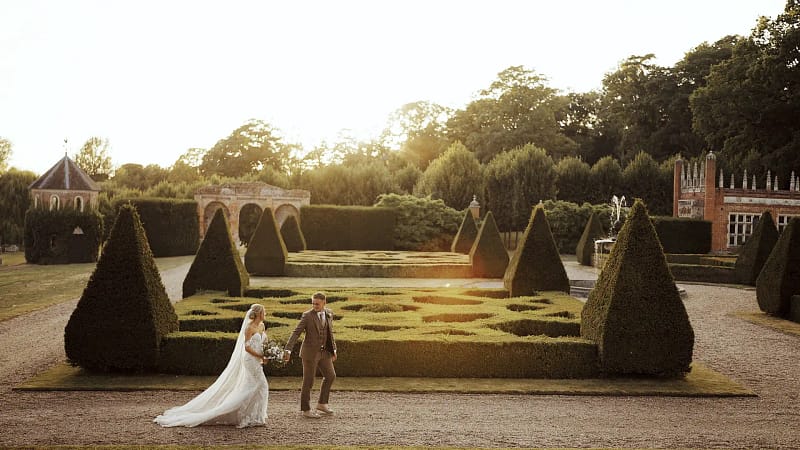 Couple walking in beautiful garden at sunset.
