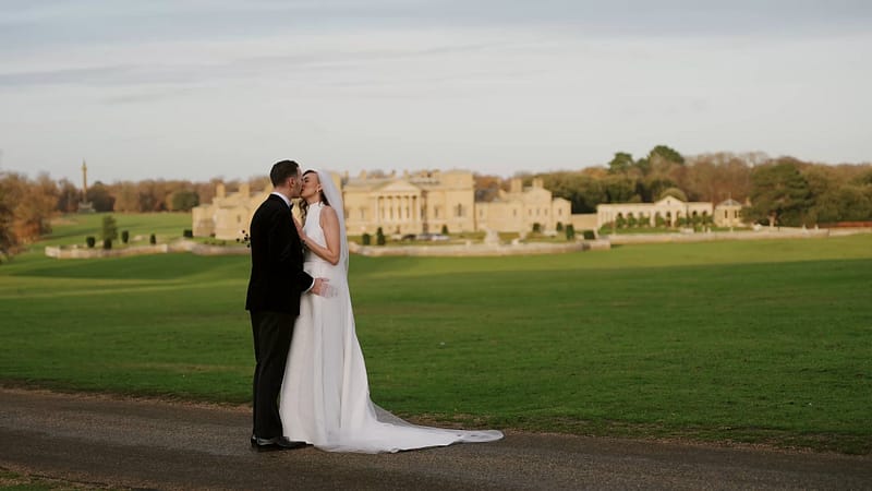 Bride and groom kissing before Holkham Hall