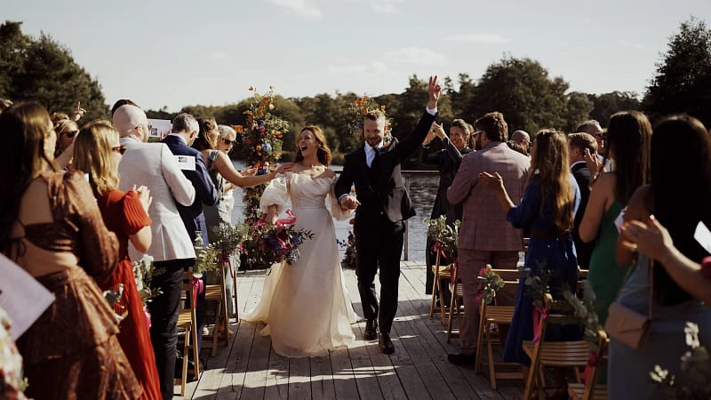 Bride and groom celebrating at outdoor wedding ceremony.