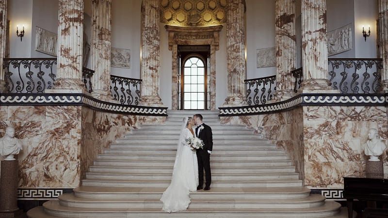 Bride and groom on grand staircase indoors