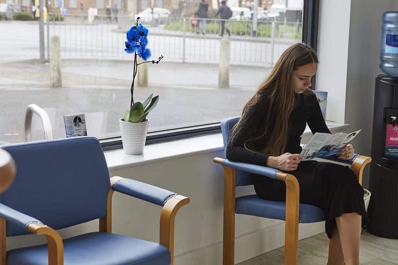 Girl sitting reading leaflet in reception area