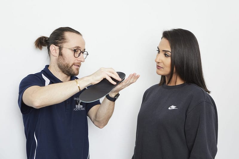podiatrist explaining orthotic to patient