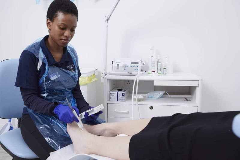 Podiatrist using doppler to find foot pulses