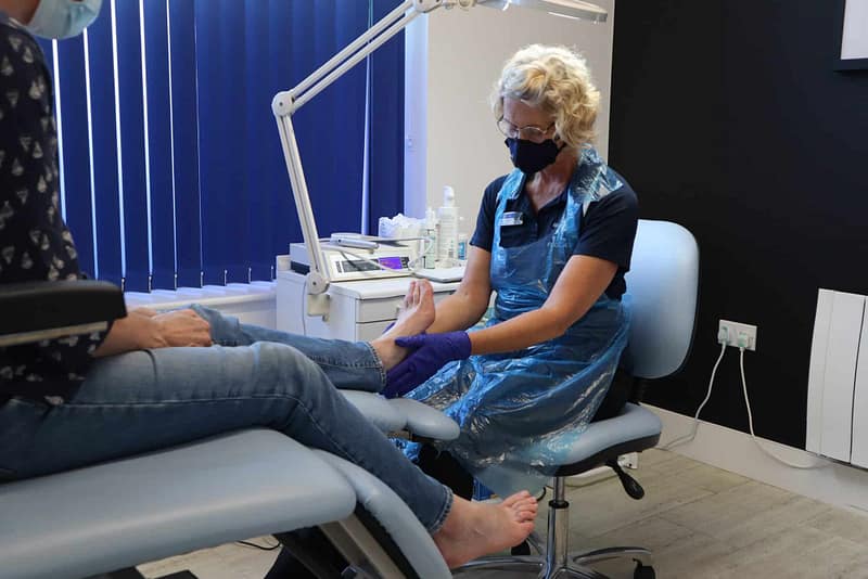 podiatrist holding sitting patient's foot