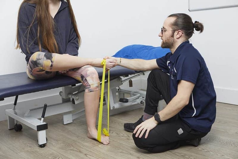 Podiatrist explaining use of theraband for exercise