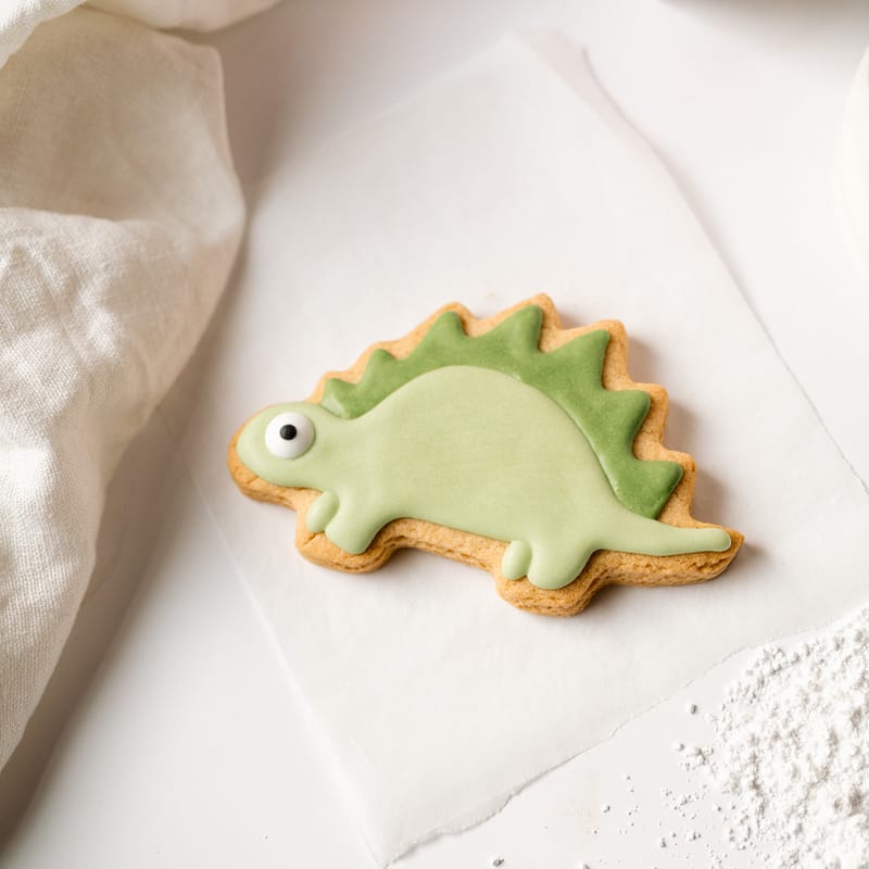 Green dinosaur-shaped sugar cookie with icing