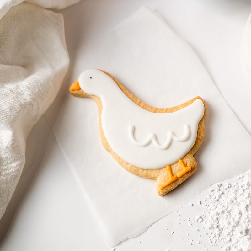 Goose-shaped iced biscuit on baking paper.