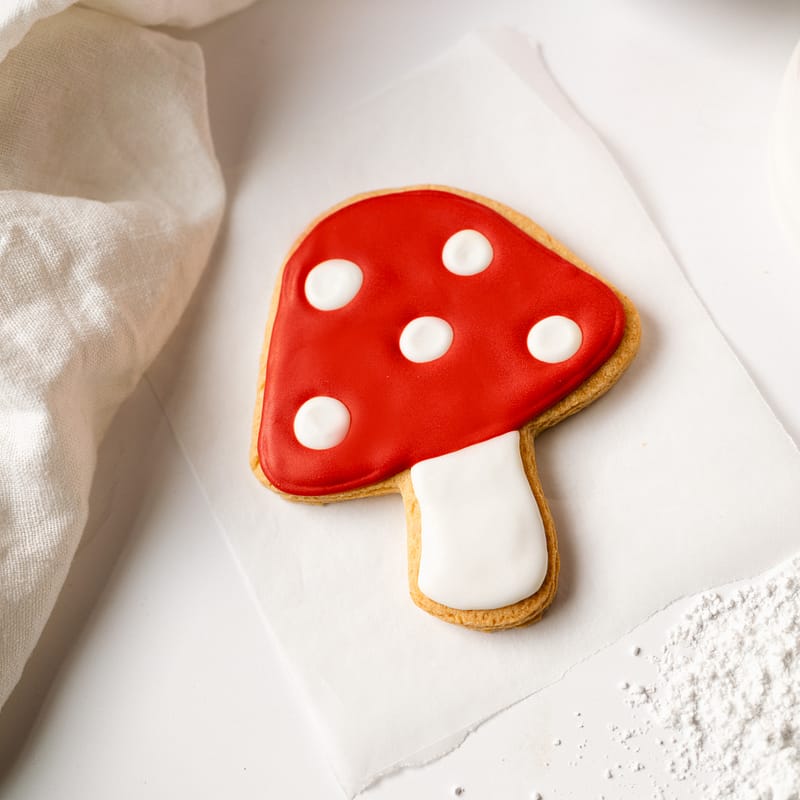 Mushroom-shaped biscuit with red and white icing.
