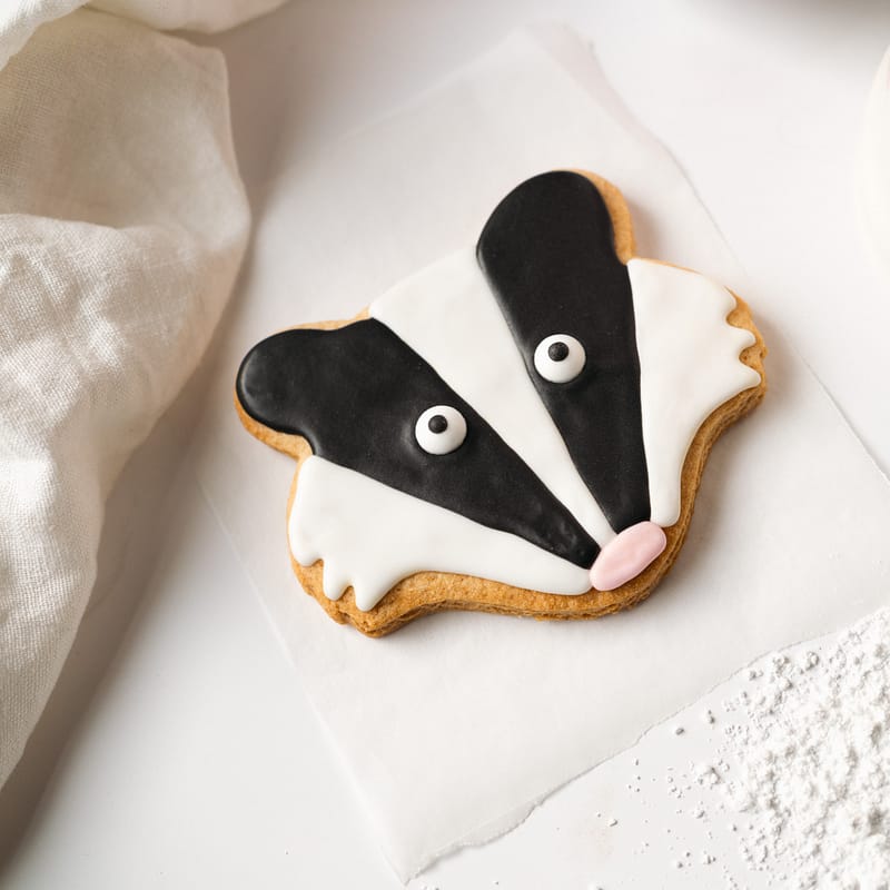 Badger-shaped biscuit with icing design.