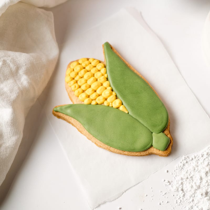 Corn-shaped biscuit with green and yellow icing.