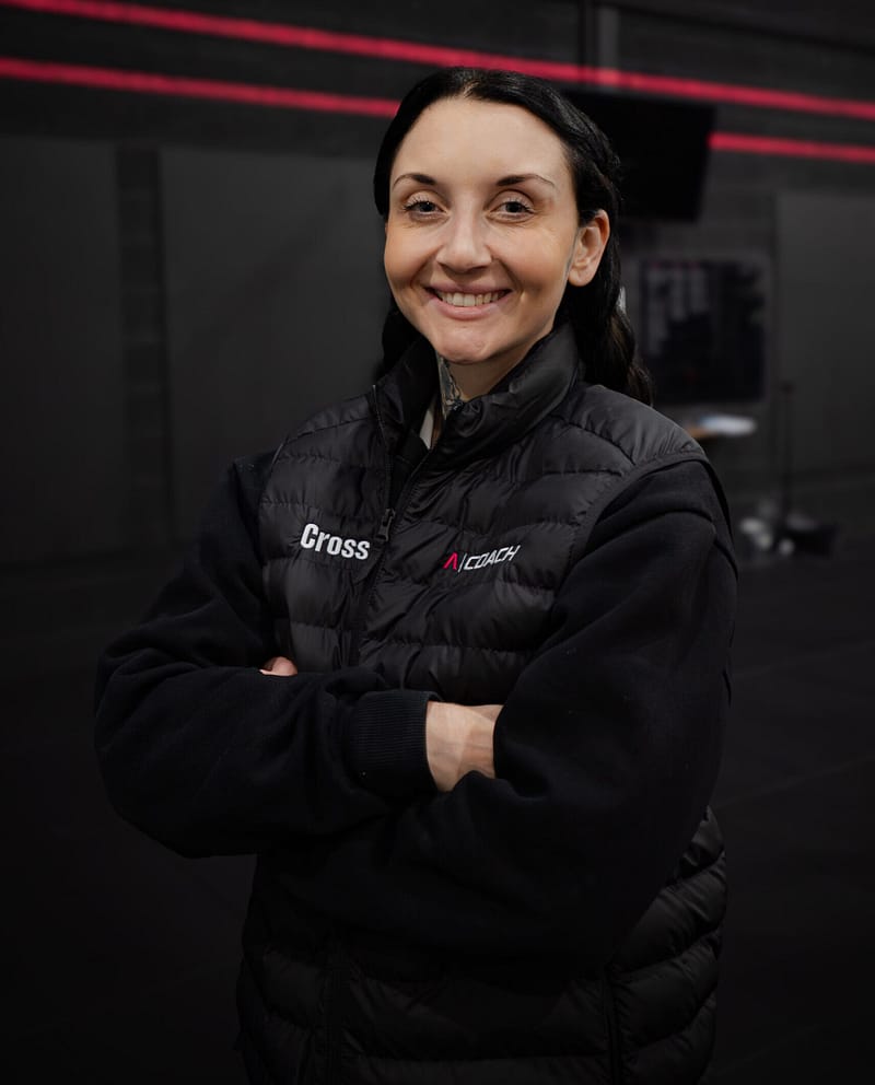 Smiling fitness coach in modern gym interior